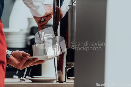 Image of The waiter preparing coffee for hotel guests. Close up photo of service in modern hotels