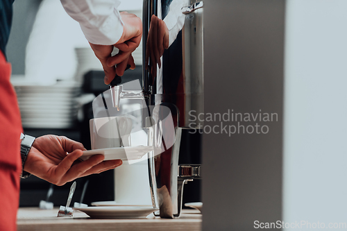 Image of The waiter preparing coffee for hotel guests. Close up photo of service in modern hotels
