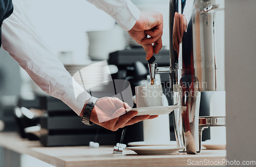 Image of The waiter preparing coffee for hotel guests. Close up photo of service in modern hotels