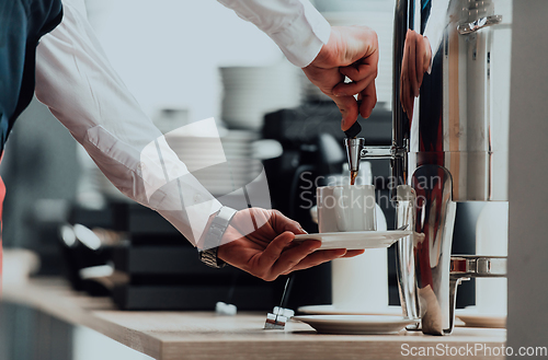 Image of The waiter preparing coffee for hotel guests. Close up photo of service in modern hotels