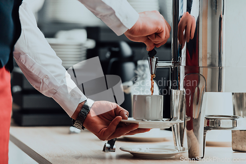 Image of The waiter preparing coffee for hotel guests. Close up photo of service in modern hotels