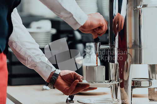 Image of The waiter preparing coffee for hotel guests. Close up photo of service in modern hotels