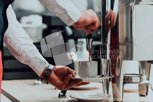 Image of The waiter preparing coffee for hotel guests. Close up photo of service in modern hotels