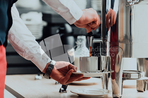 Image of The waiter preparing coffee for hotel guests. Close up photo of service in modern hotels