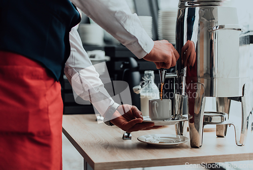 Image of The waiter preparing coffee for hotel guests. Close up photo of service in modern hotels