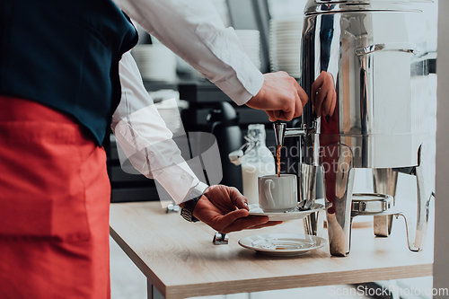 Image of The waiter preparing coffee for hotel guests. Close up photo of service in modern hotels