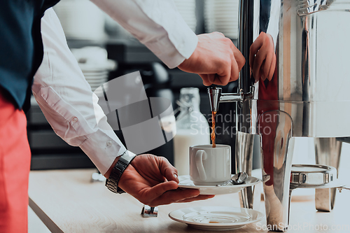 Image of The waiter preparing coffee for hotel guests. Close up photo of service in modern hotels