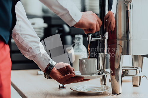 Image of The waiter preparing coffee for hotel guests. Close up photo of service in modern hotels