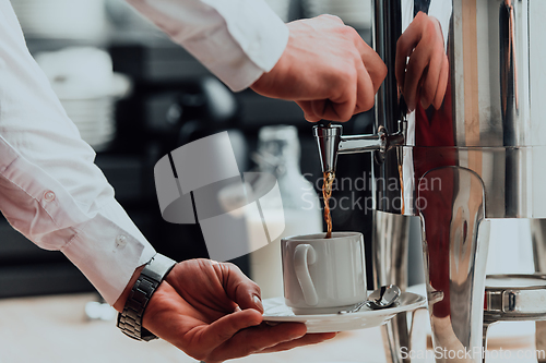 Image of The waiter preparing coffee for hotel guests. Close up photo of service in modern hotels