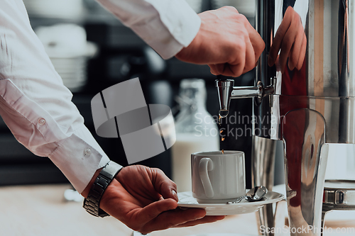 Image of The waiter preparing coffee for hotel guests. Close up photo of service in modern hotels