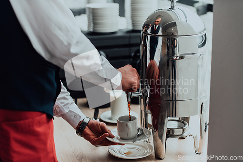 Image of The waiter preparing coffee for hotel guests. Close up photo of service in modern hotels