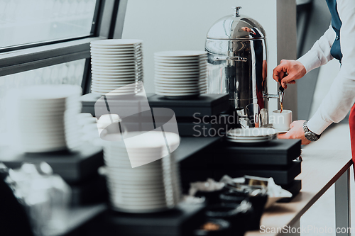 Image of The waiter preparing coffee for hotel guests. Close up photo of service in modern hotels