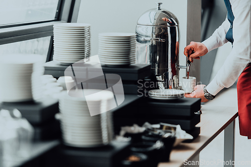 Image of The waiter preparing coffee for hotel guests. Close up photo of service in modern hotels