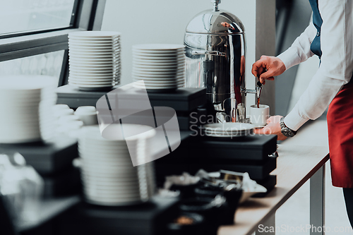 Image of The waiter preparing coffee for hotel guests. Close up photo of service in modern hotels