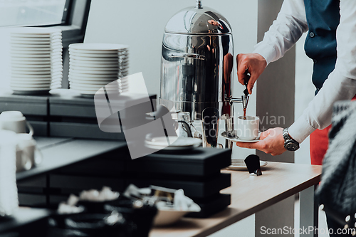 Image of The waiter preparing coffee for hotel guests. Close up photo of service in modern hotels