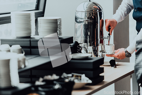 Image of The waiter preparing coffee for hotel guests. Close up photo of service in modern hotels