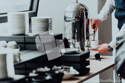 Image of The waiter preparing coffee for hotel guests. Close up photo of service in modern hotels