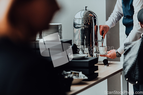 Image of The waiter preparing coffee for hotel guests. Close up photo of service in modern hotels