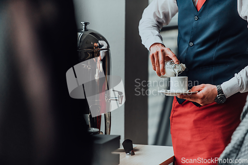 Image of The waiter preparing coffee for hotel guests. Close up photo of service in modern hotels