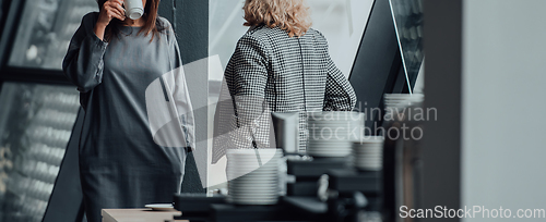 Image of Two business women are talking during a short break from a business meeting