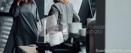 Image of Two business women are talking during a short break from a business meeting