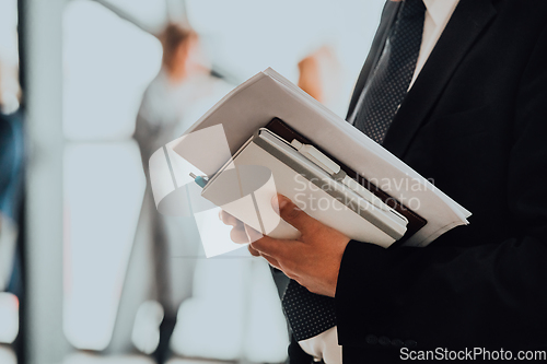 Image of Cose up photo of a womans hand holding business documents