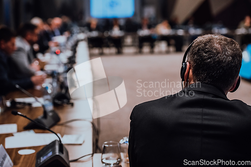 Image of Speaker at Business Conference with Public Presentations. Audience at the conference hall. Entrepreneurship club. Rear view. Panoramic composition. Background blur.