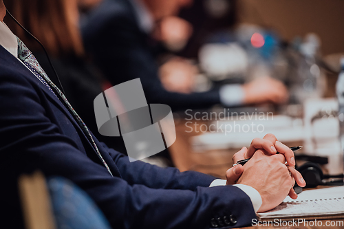 Image of Closeup shot of business people hands using pen while taking notes on education training during business seminar at modern conference room