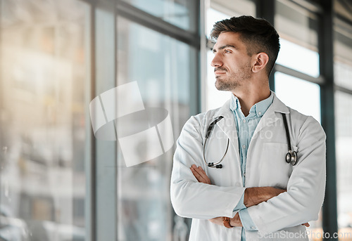 Image of Doctor, thinking and arms crossed at the window in hospital, clinic and vision for the future of healthcare, medicine or surgery. Man, medical worker or intern with decision, choice and ideas