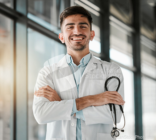 Image of Crossed arms, happy and portrait of a male doctor with a stethoscope in a medical hospital. Confidence, smile and professional young man healthcare worker or surgeon with pride in medicare clinic.