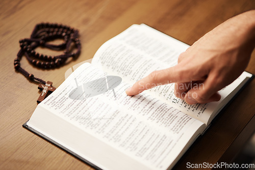 Image of Hands, person and reading bible with rosary cross for praying, spiritual faith and holy worship of God. Closeup of christian studying religion, gospel prayer books and learning praise to Jesus Christ