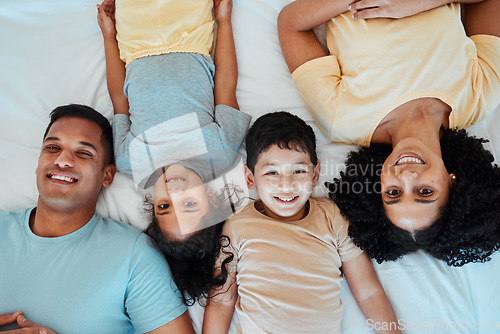 Image of Top view, portrait and parents with children on bed for bonding, quality time and affection in morning. Happy, love and above of mother, father and kids in bedroom for fun, sleeping and relax at home