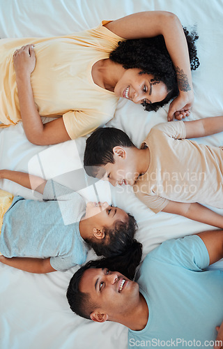 Image of Top view of mother, father and children in bed for bonding, quality time and affection in morning. Happy, love and above of mom, dad and kids in bedroom for fun, sleeping and relax together at home