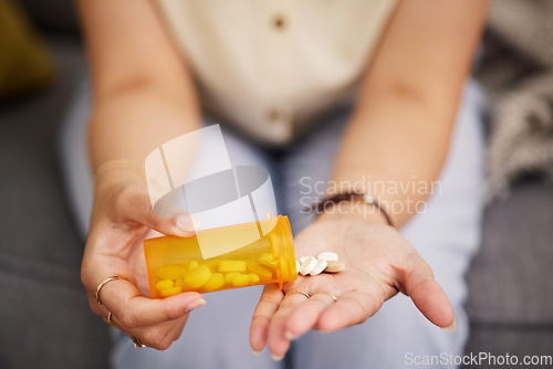 Image of Woman hands, medicine and bottle of tablet, iron supplements and daily vitamins at home. Closeup, container of pills and prescription drugs in palm of sick person for medical, product and healthcare