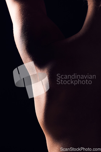 Image of Back, dark and skin texture of person with skincare macro on a studio background for body health or wellness. Healthy, muscle and natural closeup creative for cosmetic beauty in shadow with art deco