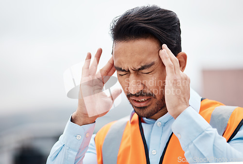 Image of Headache, stress and male construction worker on a rooftop of a building for inspection or maintenance. Migraine, engineering and young man foreman with burnout while working in an urban town.