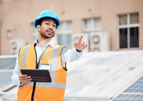 Image of Tablet, planning and male construction worker on a rooftop of a building for inspection or maintenance. Industry, engineering and young man foreman with digital technology working in an urban town.