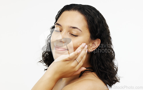 Image of Face, makeup and skincare with a woman in studio isolated on a white background touching her skin. Portrait, beauty and facial with an attractive young female rubbing her cheek for natural treatment