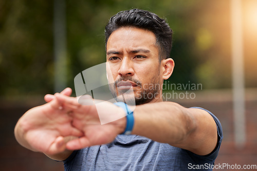 Image of Serious, fitness or man stretching arms in exercise, training or healthy sports outdoor. Face of strong asian athlete focus to warm up in workout, performance or thinking of mobility, energy or power