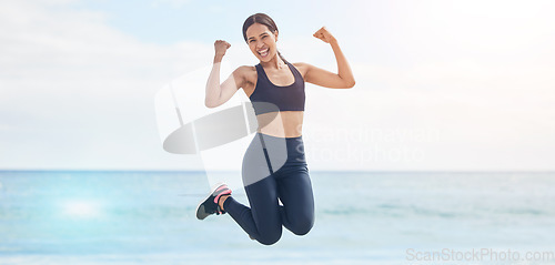 Image of Portrait, freedom and fitness woman jump at the beach with celebration after running, training or workout success in nature. Exercise, jumping and female runner at the sea celebrating goal milestone