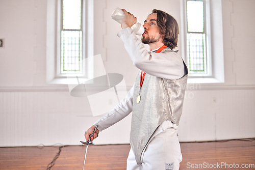 Image of Fencing, sports and man drinking water after training, fitness or workout with sword in club. Bottle, fencer or athlete with beverage after exercise with liquid for nutrition, body health or wellness