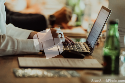 Image of Close up photo of a woman's hand typing on a laptop at a seminar