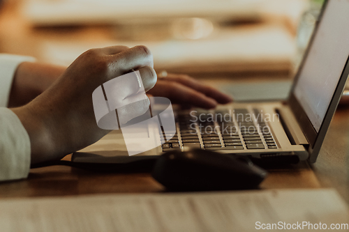 Image of Close up photo of a woman's hand typing on a laptop at a seminar