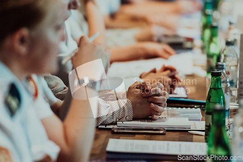 Image of Closeup shot of business people hands using pen while taking notes on education training during business seminar at modern conference room