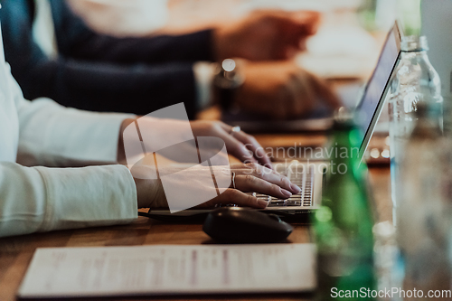 Image of Close up photo of a woman's hand typing on a laptop at a seminar