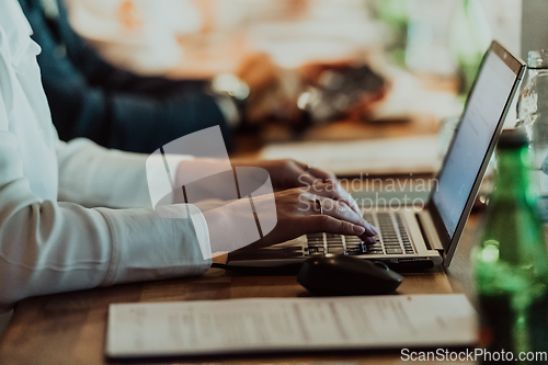 Image of Close up photo of a woman's hand typing on a laptop at a seminar