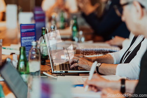 Image of Close up photo of an elderly woman typing on a laptop at a seminar