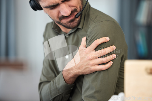 Image of Call center man, shoulder pain and muscle in office, communication expert or consultant with burnout. Young telemarketing agent, crm and stress injury with accident, problem or fatigue in workplace