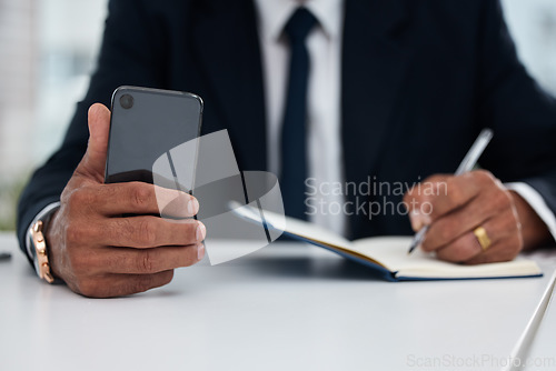 Image of Table, hands and businessman with phone and notebook for planning, schedule or work agenda. Office, writing and a corporate employee with a planner and a mobile for an app while working on a reminder