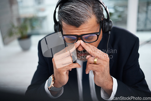 Image of Depressed, tired and man in a call center with a headache from telemarketing or technical support. Sad, fail or a mature customer service employee or boss with a mistake or anxiety with communication